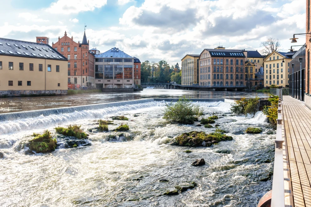 Norrköpings industrilandskap med gula stenfasader och röda tegelbyggnader. Strömmen är i förgrunden.