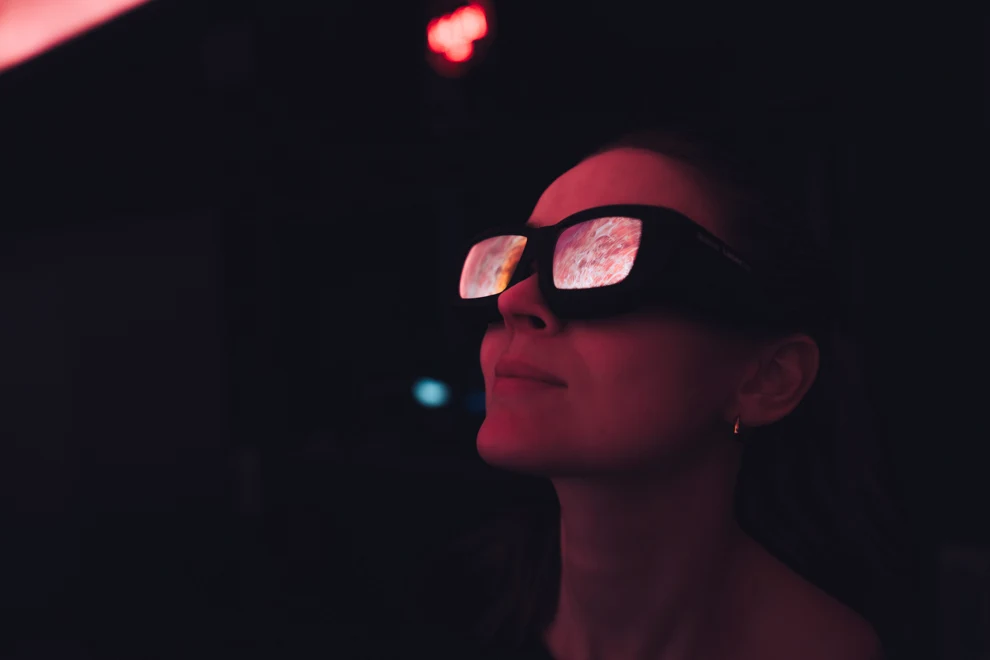 Kvinna tittar med 3D-glasögon på en skärm.
